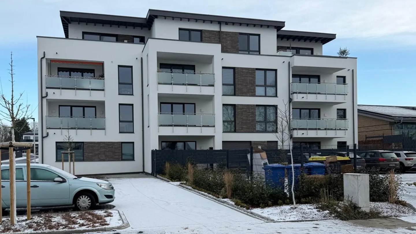Modernes Mehrfamilienhaus mit hochwertiger Fassadengestaltung und Fliesenarbeiten im Neubau.