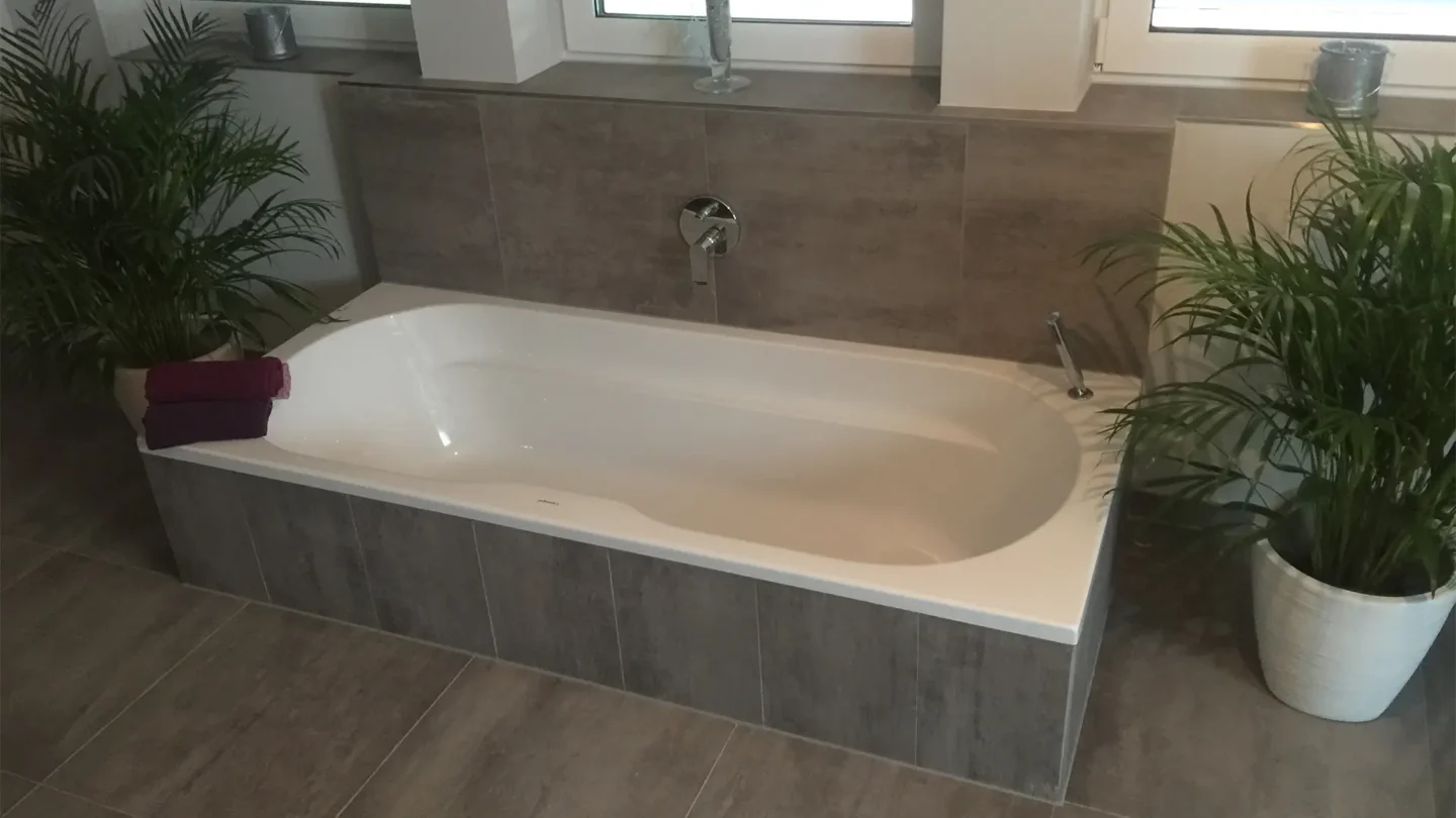 Modernes Badezimmer mit bodengleicher Dusche und großformatigen grauen Fliesen.
